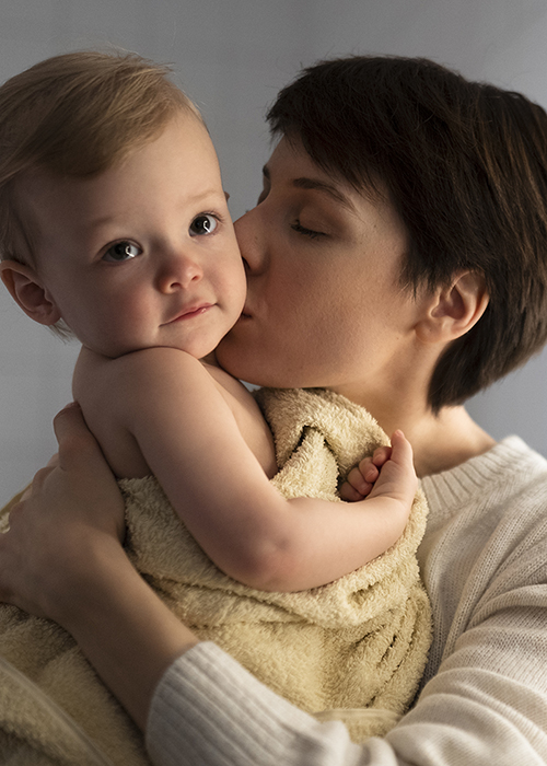 medium-shot-mother-kissing-baby